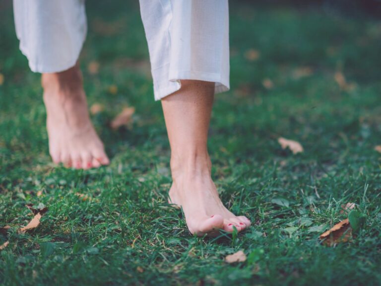 Pieds nus marchant sur herbe au soleil