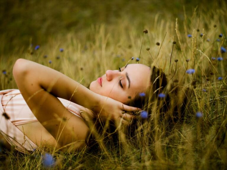 Femme allongée dans l’herbe, yeux fermés