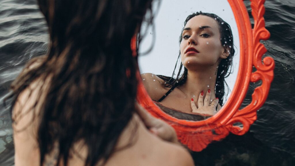 Reflet d’un visage dans l’eau, symbole de reconnexion et de s’autoriser à être soi
