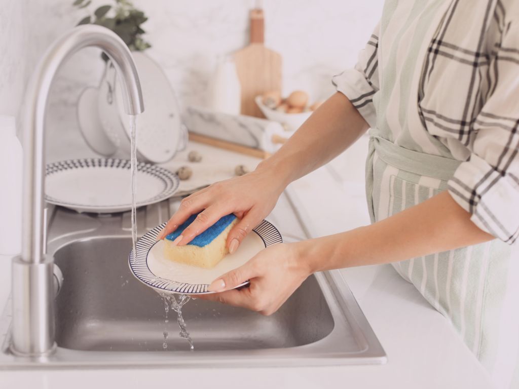 Mains de femme dans un évier, en train de faire la vaisselle conseils bien-être pour préserver son énergie septembre